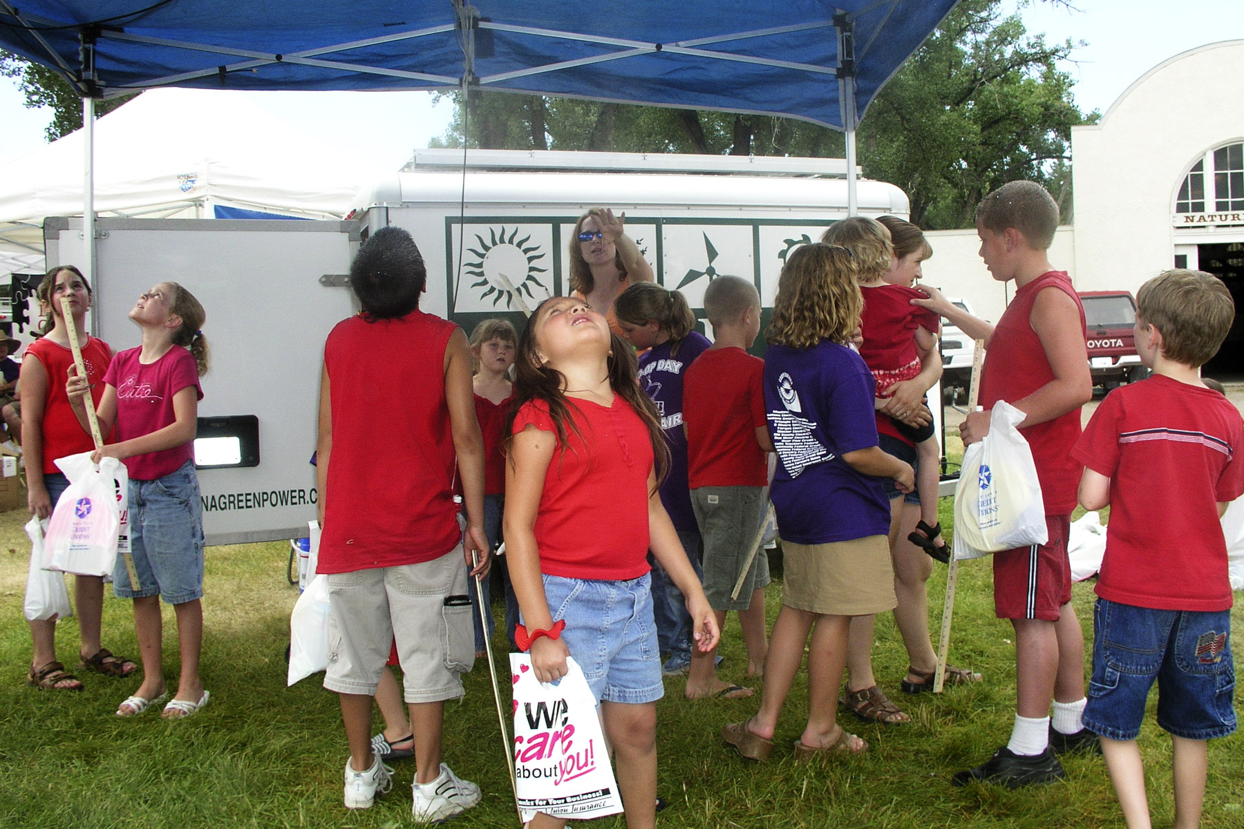 A group of kids investigate the MREA trailer's misting system.